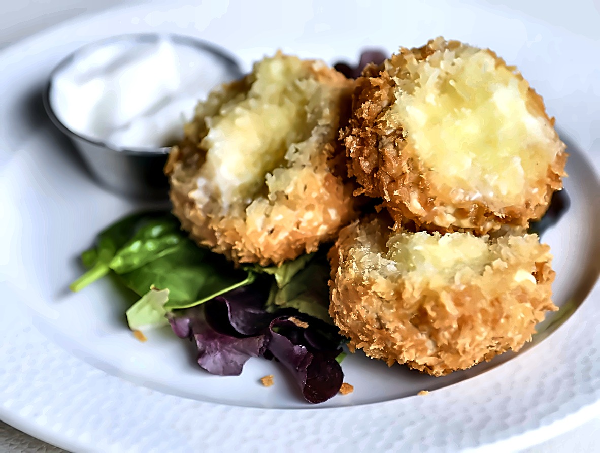 Crispy breaded goat cheese with dressed leaves and dip