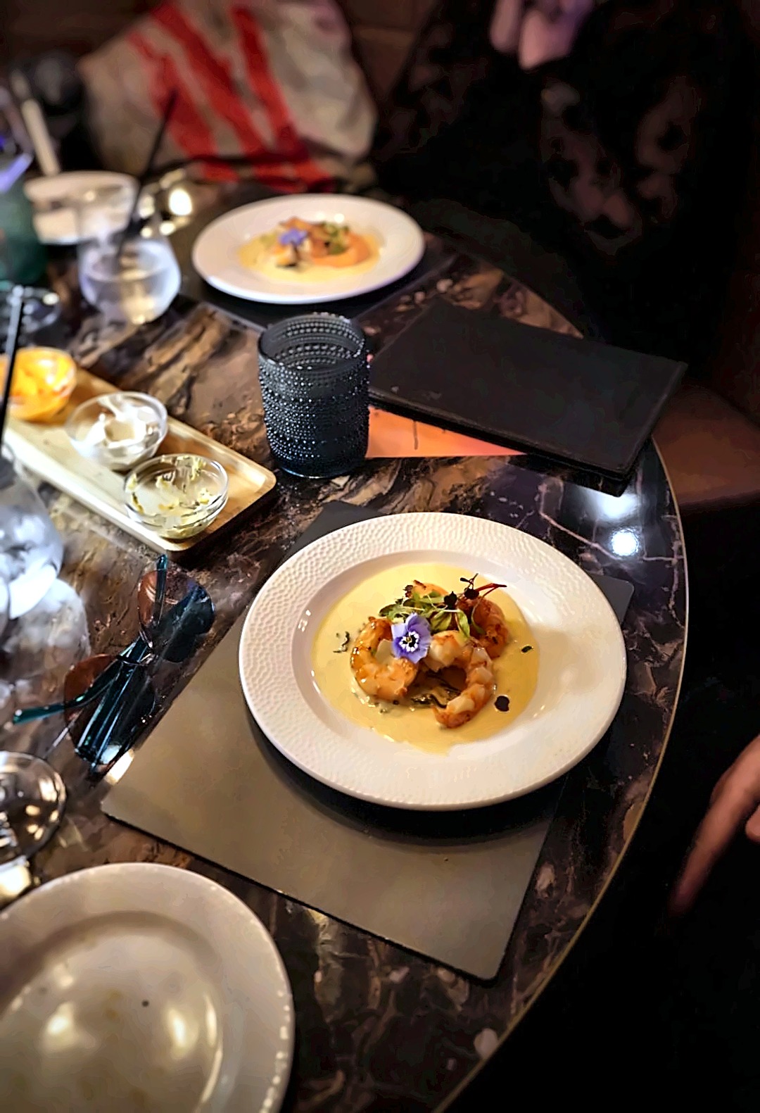 Pan-fried prawns in a creamy bisque, served on the marble table