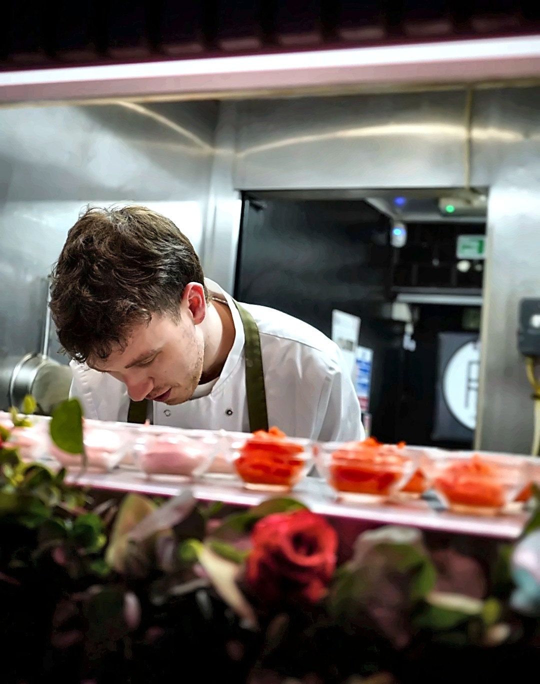 Chef plating desserts at the kitchen pass