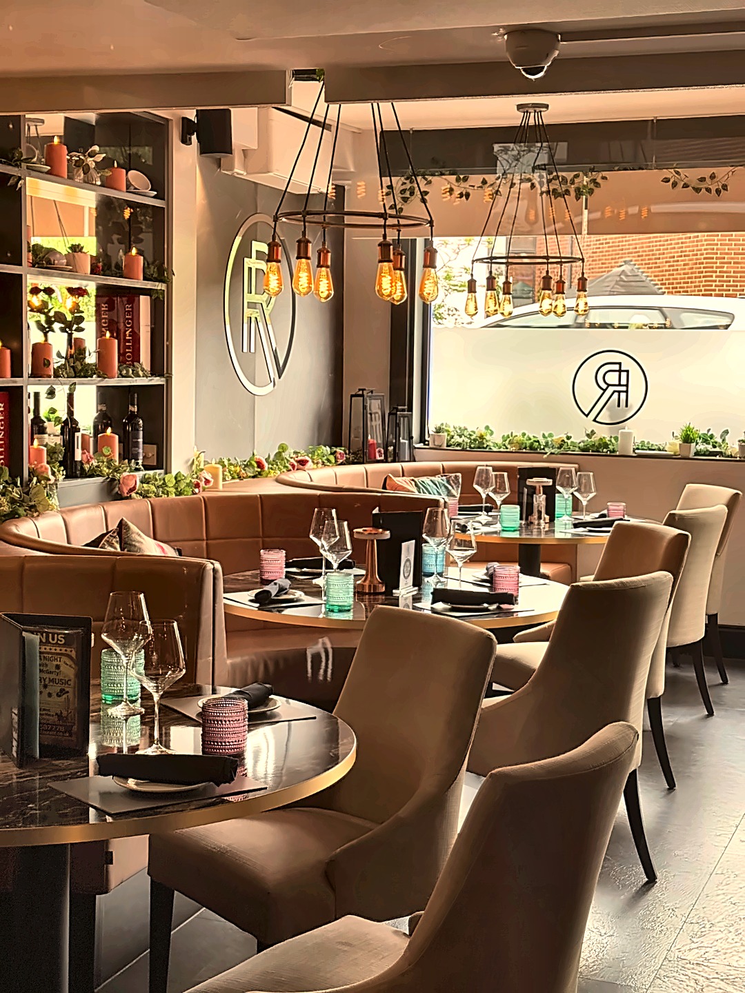 Roy's bar area with monogram, Edison-bulb lighting and greenery